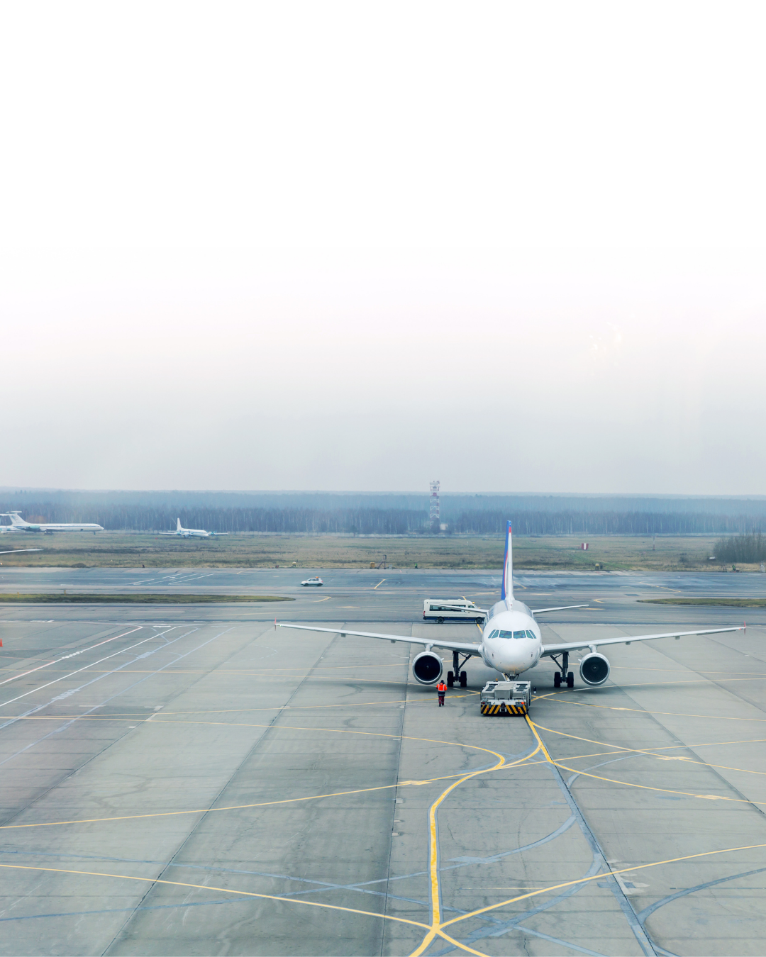Airliner on the apron with ground crew and a pushback tug