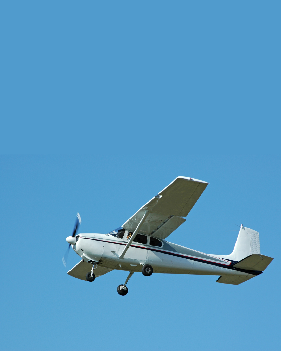 Light training aircraft climbing out against a clear sky